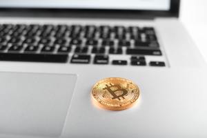 Golden bitcoins as main cryptocurrencies placed on silver laptop keyboard